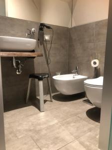 ein Badezimmer mit einem Waschbecken, einer Badewanne und einem WC in der Unterkunft Residenza Solferino in Cremona