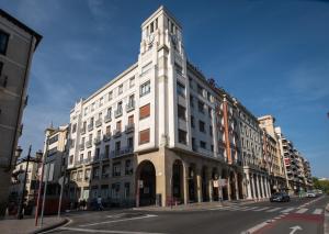 a large white building with a clock tower on a street at PRINCIPE DE VERGARA ROOMS Lujo en el centro de Logroño in Logroño