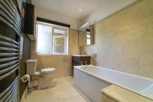 a bathroom with a tub and a toilet and a sink at The Quackery in Langport +76 photos