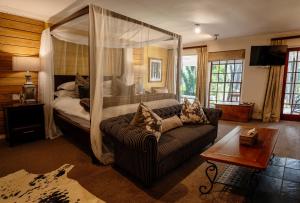 Silvermist Wine Estate في كيب تاون: غرفة معيشة مع سرير وأريكة