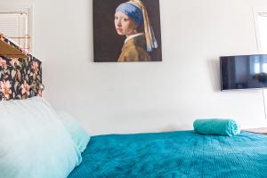 een slaapkamer met een bed met een schilderij van een vrouw bij The New Lake Boathouse in Amsterdam