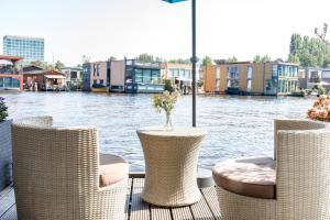 a group of chairs and a table with a vase of flowers at The New Lake Boathouse in Amsterdam