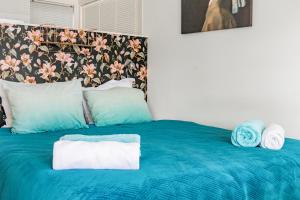 Una cama azul con dos toallas encima. en The New Lake Boathouse en Ámsterdam