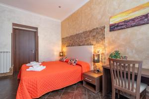 Schlafzimmer mit einem orangenen Bett und einem Schreibtisch in der Unterkunft Alis Laura in Rom