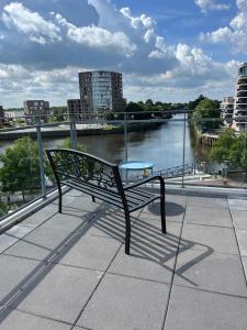 a bench sitting on a ledge next to a river at Penthouse-Wohnung mit Flussblick in Oldenburg