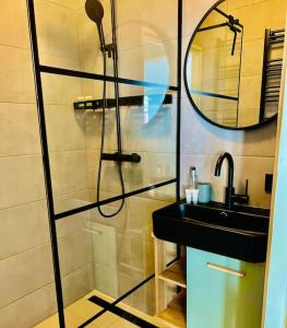 a bathroom with a shower and a sink and a mirror at Ruim comfortabel appartement centrum Breda MET restaurant! in Breda