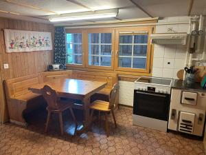 una cocina con mesa de madera y sillas. en Via Alpsu 143, en Sedrun