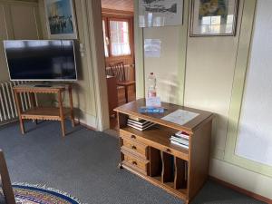 a living room with a tv and a wooden table at Via Alpsu 143 in Sedrun