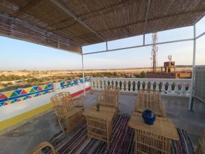 a patio with chairs and tables on a roof at Private House with Garden and terrace in Aswan in Aswan