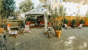 a patio with a table and chairs and plants at arte vida boutique guesthouse in Salzburg