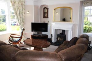 a living room with a couch and a fireplace at Lake District 4 Bedroom House, Ings, Cumbria. in Kendal