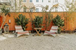 four chairs and a table in a courtyard with plants at arte vida boutique guesthouse in Salzburg