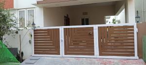 a wooden fence in front of a house at SHI's Vilva AC 2BHK in Coimbatore