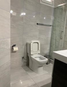 a white bathroom with a toilet and a sink at Lovely Country House! in Dhesfína