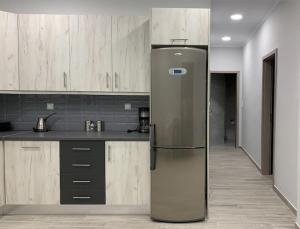 a stainless steel refrigerator in a kitchen with wooden cabinets at Lovely Country House! in Dhesfína