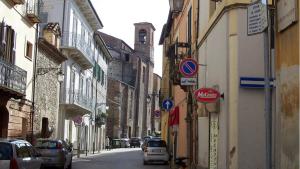 an alley with cars parked on a street with buildings at La Casetta in Teramo