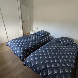 two beds sitting next to each other in a bedroom at Maison neuve à 13 min des Sables in Talmont