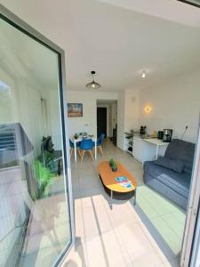 a living room with a couch and a table at Casa Rosa : appartement moderne avec balcon in Tassin-la-Demi-Lune +9 photos