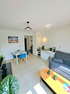 a living room with a blue couch and a table at Casa Rosa : appartement moderne avec balcon in Tassin-la-Demi-Lune