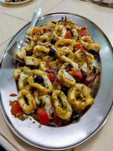 a plate of food with shrimp and vegetables on a table at BeB Sardegna2 Anjumasa village in Watamu