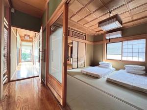 two beds in a large room with a window at 640平米・海景房・独栋别墅・古民家“唯未亭” in Bōde