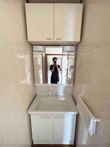 a man taking a picture of a bathroom mirror at 640平米・海景房・独栋别墅・古民家“唯未亭” in Bōde