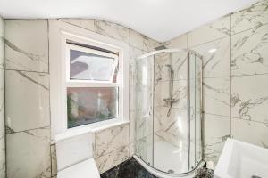 baño con ducha y ventana en A Stunning 3Bed house with WiFi en Chatham