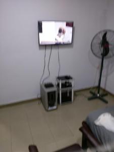 a living room with a flat screen tv and a fan at Chinaka guest house in Lagos