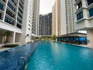 une grande piscine au milieu de certains bâtiments dans l'établissement Trefoil Studio Comfy 3-Shah Alam, à Shah Alam