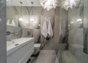 une salle de bain avec un lavabo, des toilettes et des lumières dans l'établissement Eclipse Silver Room, à Bielsko-Biała
