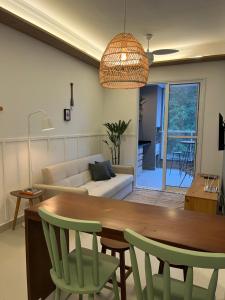 Una sala de estar con una mesa y sillas y un sofá. en Apartamento Ubatuba 405, en Ubatuba