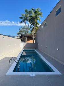 una piscina al costado de una casa en Apartamento Ubatuba 405, en Ubatuba