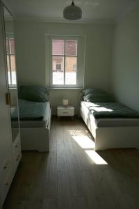 a bedroom with two beds and two windows at Ferienwohnung Sieben Eulen in Garrey (Hoher Fläming) 