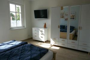 a bedroom with a bed and a dresser with a television at Ferienwohnung Sieben Eulen in Garrey (Hoher Fläming) 