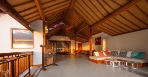 uma sala de estar com um grande tecto de madeira em Bali Marina Villa's em Amed