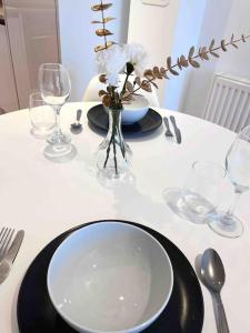 una mesa blanca con un plato y un jarrón con flores en Beautiful 2 Bed Apartment In Bow en Londres