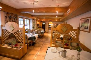 Appartementhaus zur Post في باد جاستاين: مطعم فيه طاولات وكراسي في الغرفة