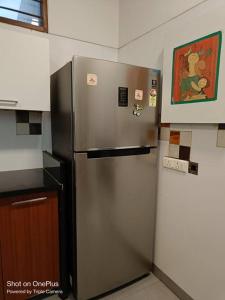 a stainless steel refrigerator in the corner of a kitchen at BnBBuddy-Majestic Home near NFC in New Delhi
