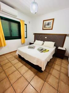 una camera da letto con un grande letto bianco con tende gialle di Playa Park a Puerto del Carmen