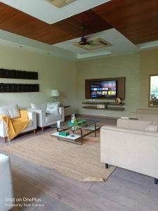 a living room with white furniture and a flat screen tv at BnBBuddy-Majestic Home near NFC in New Delhi