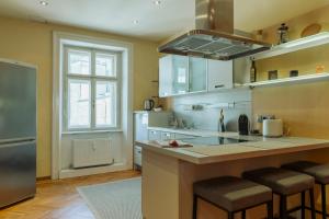 a kitchen with a sink and a counter with bar stools at arte vida in Salzburg