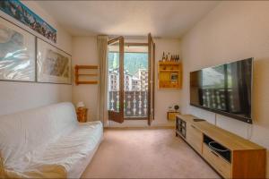 uma sala de estar com um sofá e uma televisão de ecrã plano em Chamonix Sud - Bâtiment Iris 374 - Happy Rentals em Chamonix-Mont-Blanc