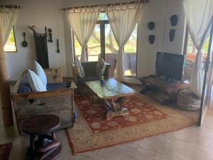 a living room with a couch and a table at Zi Villa Beach Cottage in Matemwe