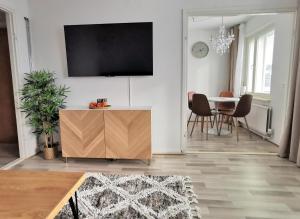 un soggiorno con tavolo e TV a parete di Rovaniemi Cityhome Pekankatu a Rovaniemi 1 altra foto