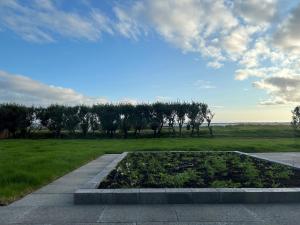 uma vista para um jardim com árvores num campo em SK52 by the Sea, Unique spacious luxury em Reykjavík