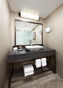 a bathroom with a sink and a large mirror at Sheraton Gateway Los Angeles Hotel in Los Angeles