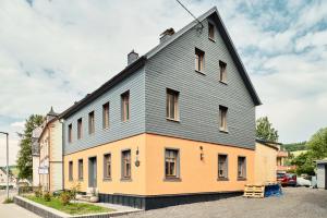 a house with a gray roof and a yellow and orange at Neidorf Inn in Neudorf