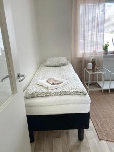 - un petit lit dans une chambre avec fenêtre dans l'établissement Upea yksiö Kotkan Katariinassa, à Kotka