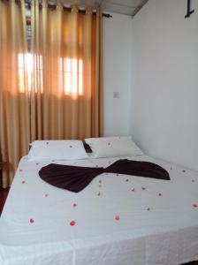 a bedroom with a bed with red flowers on it at Weligama Elite Guest in Weligama
