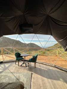 Zimmer mit 2 Stühlen, einem Tisch und Aussicht in der Unterkunft Shatyly Lake ViewGlamping in Bokonbayevo